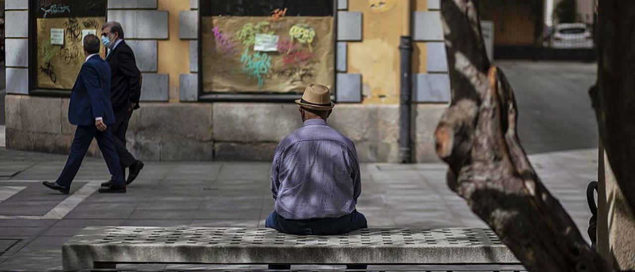 Una persona mayor sentada en la calle Santa Clara