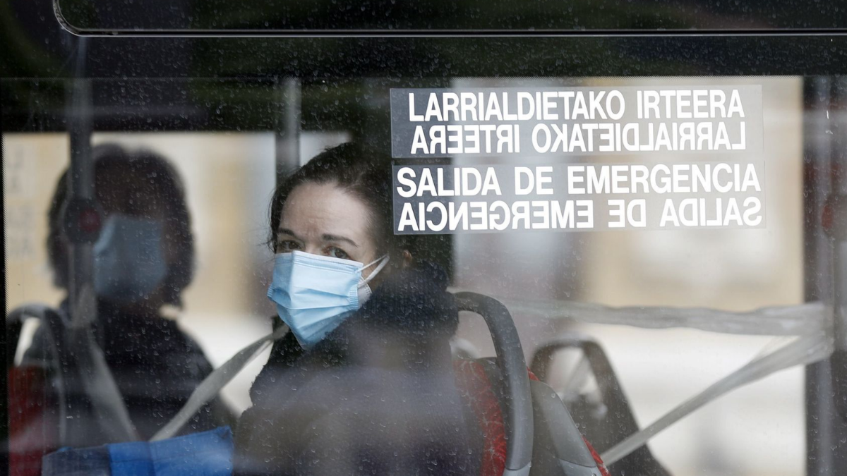 Una persona con mascarilla en un autobús.