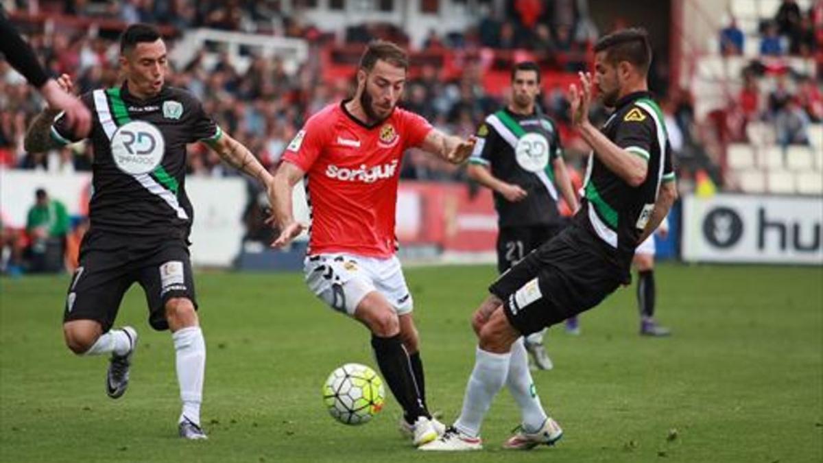 Palanca, autor del tercer gol de Nástic, controla un balón ante dos jugadores del Córdoba.