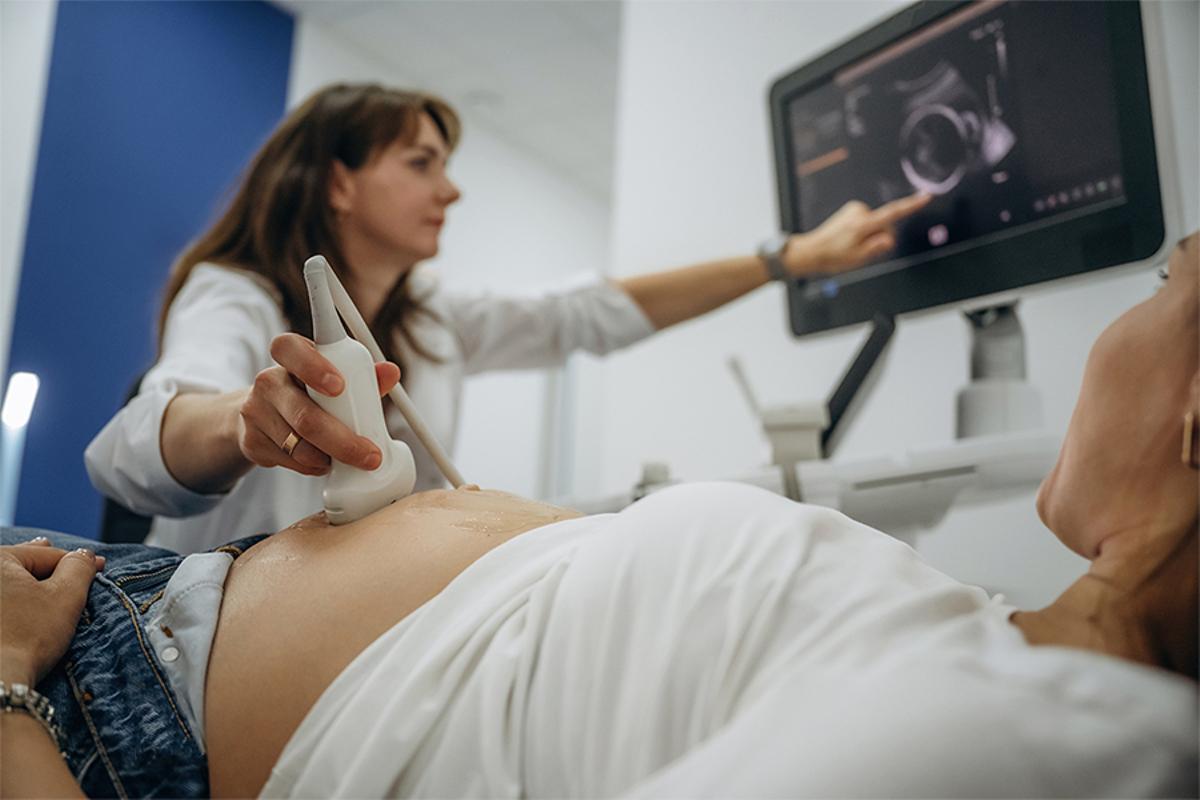 Una parella juntament amb una doctora fent una ecografia per veure al nadó.
