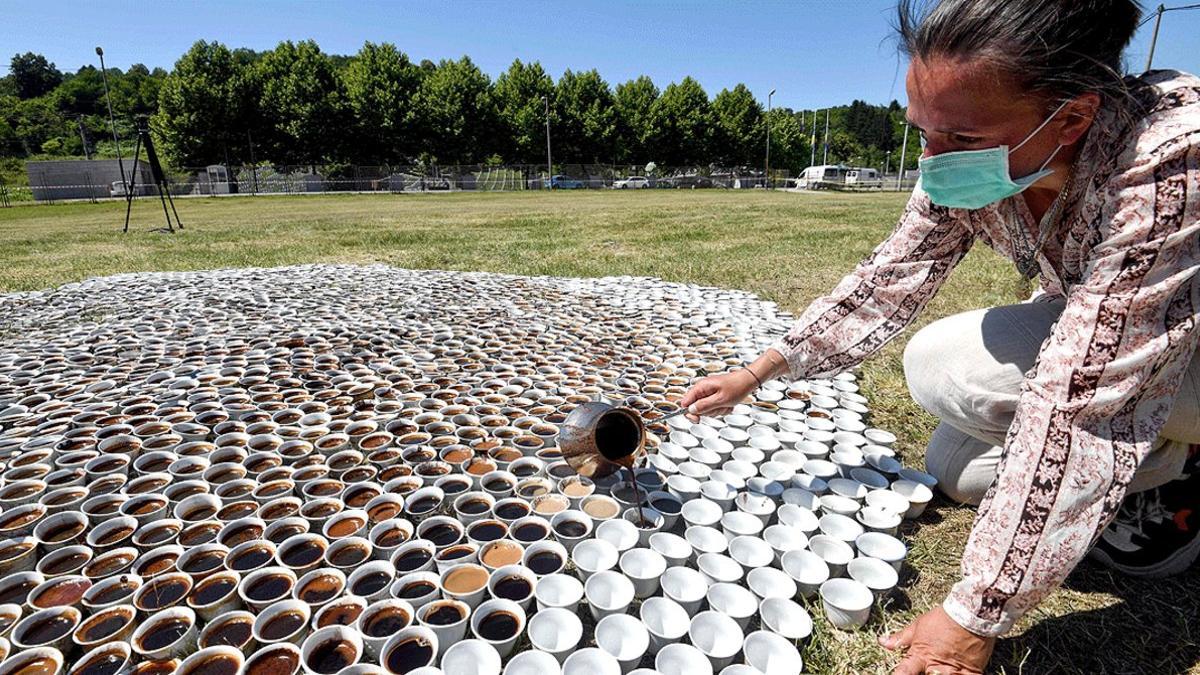 La artista bosnia Aida Šehovi¿ llena las tazas de café de la instalación '¿Por qué no estás aquí?', cerca del cementerio conmemorativo de la matanza de Srebrenica, en Potocari, el 10 de julio