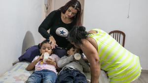 Nubia Santamaría Ramírez y su nuera, Nora Liliana, junto a sus nietos Sofía y Dominic, que toman un biberón hecho con pasta hervida.