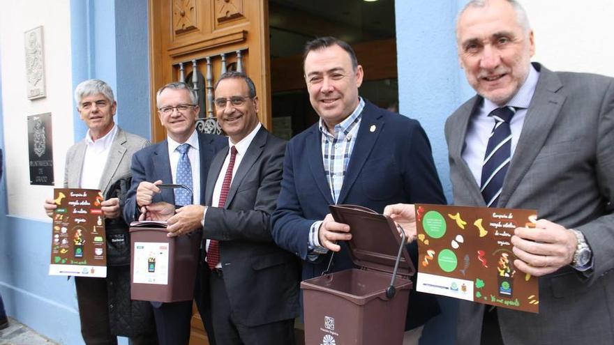 De izquierda a derecha, el gerente de Cogersa, Santiago Fernández; el director general de Calidad Ambiental, Manuel Gutiérrez; el consejero de Medio Ambiente, Fernando Lastra; el alcalde de Grado, José Luis Trabanco, y el viceconsejero de Medio Ambiente, Benigno Fernández Fano, ayer, en Grado, con los contenedores que tendrán los hogares para la recogida de residuos orgánicos.