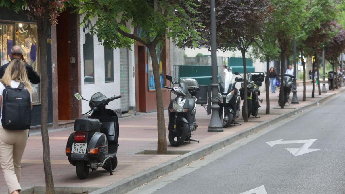 Centro 8 Motos ocupando espacio en la acera de la calle Canfranc. | MIGUEL ÁNGEL GRACIA