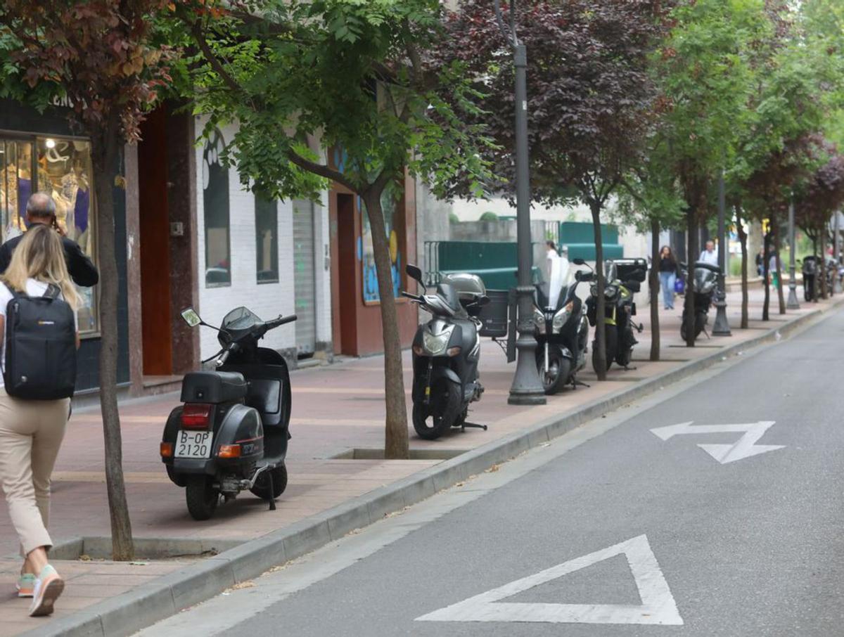 Centro 8 Motos ocupando espacio en la acera de la calle Canfranc.  | MIGUEL ÁNGEL GRACIA