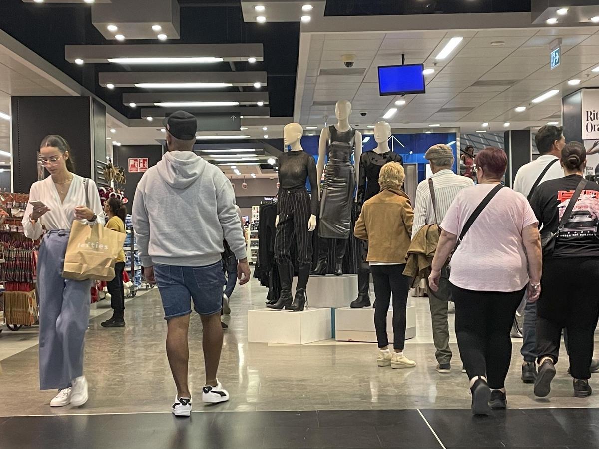 Un grupo de personas entra a la tienda de un centro comercial, este lunes.