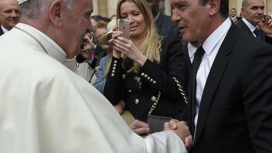 El Papa saluda a Banderas y la novia del actor los fotografía. // Efe