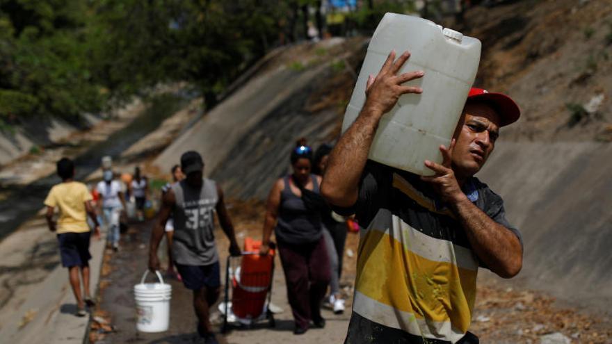 Venezolanos con garrafas llenas de agua.