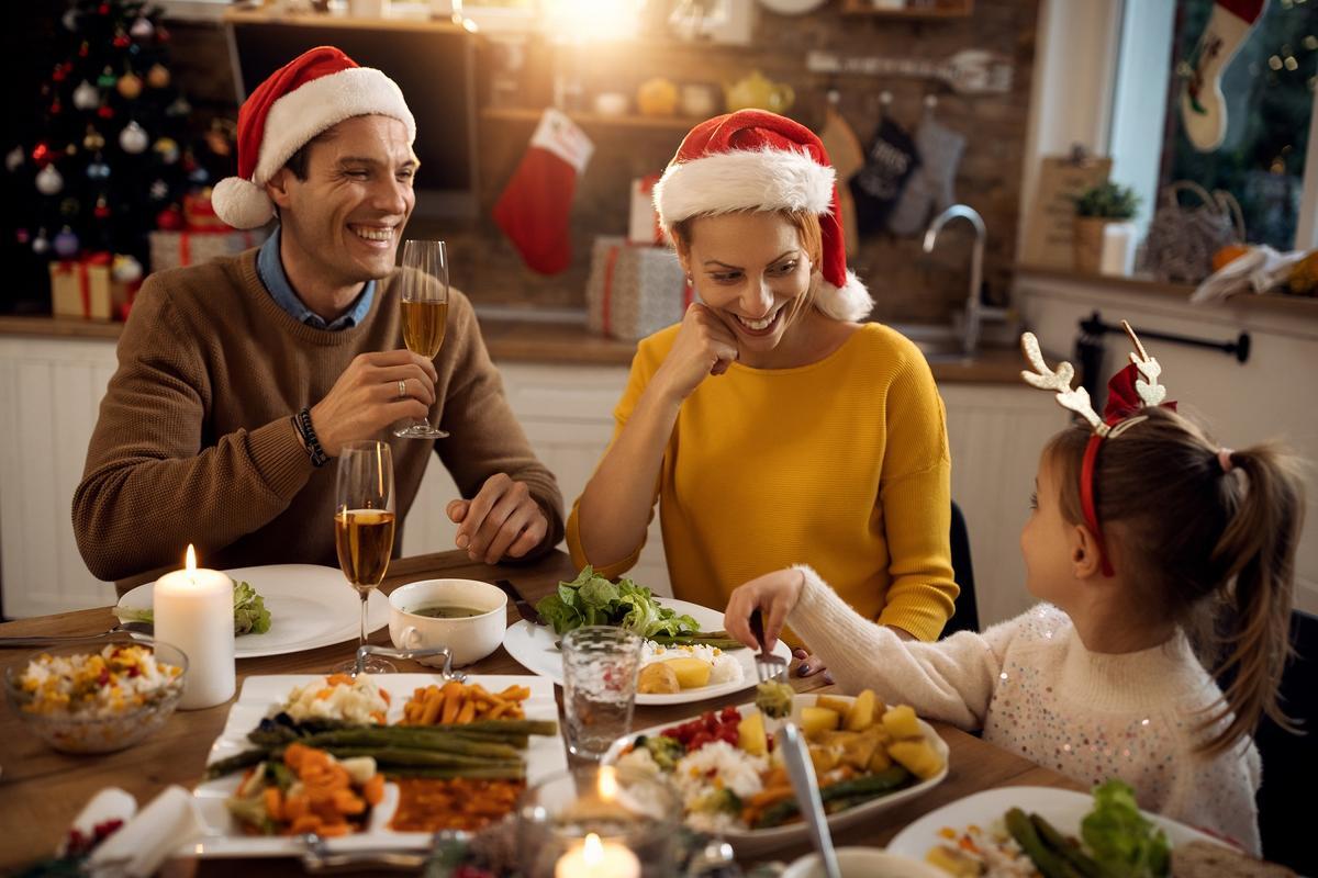 Happy family having fun while talking during Christmas lunch in dining room.