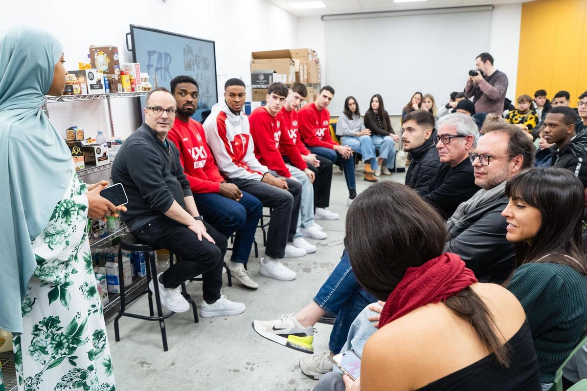 Els jugadors del Baxi i Diego Ocampo observen atentament la intervenció d'una alumne