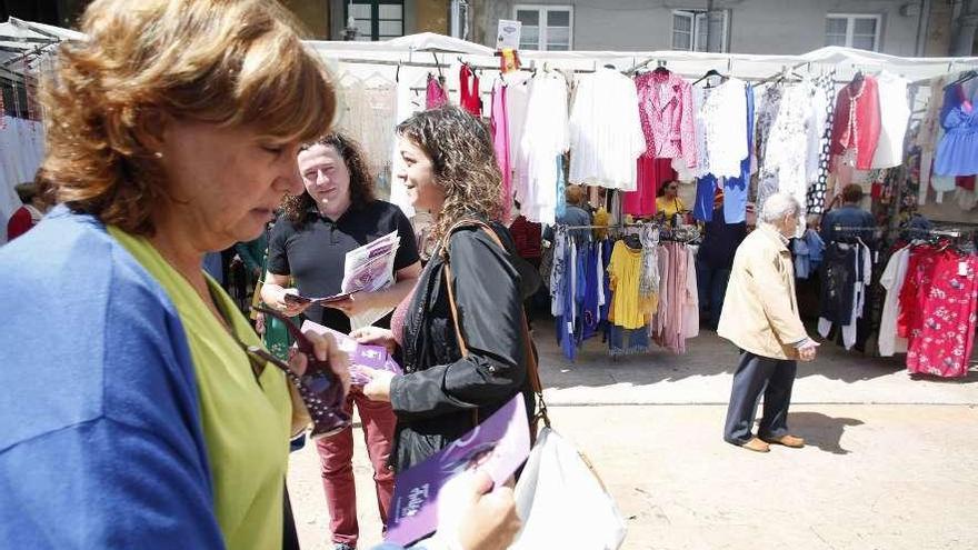 Tania González (en el centro), ayer, en el mercado, repartiendo folletos.