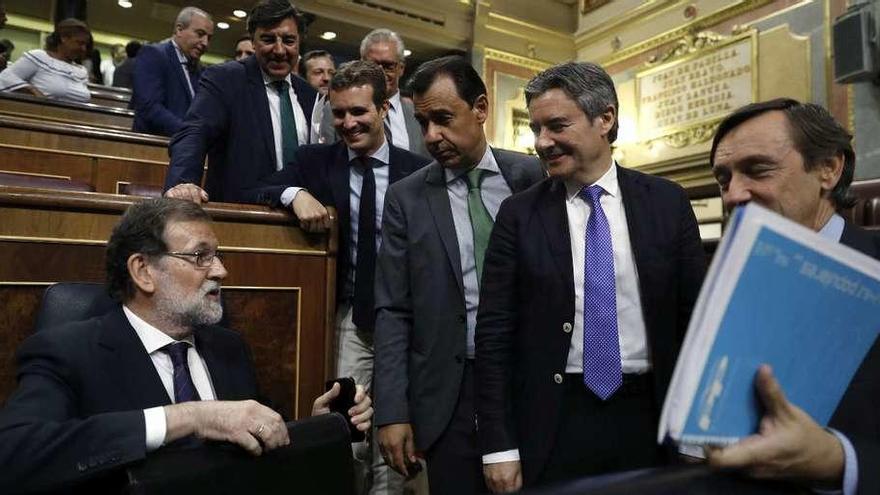 Mariano Rajoy recibe las felicitaciones de los diputados de su partido al término de la comparecencia de ayer en el Congreso. // Efe