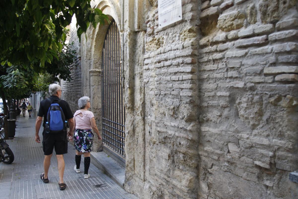 Dos turistas pasan junto a la ermita de la Aurora en la Calle San Fernando