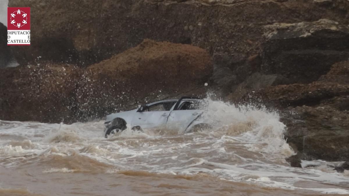 Coche arrastrado al mar por la lluvia.