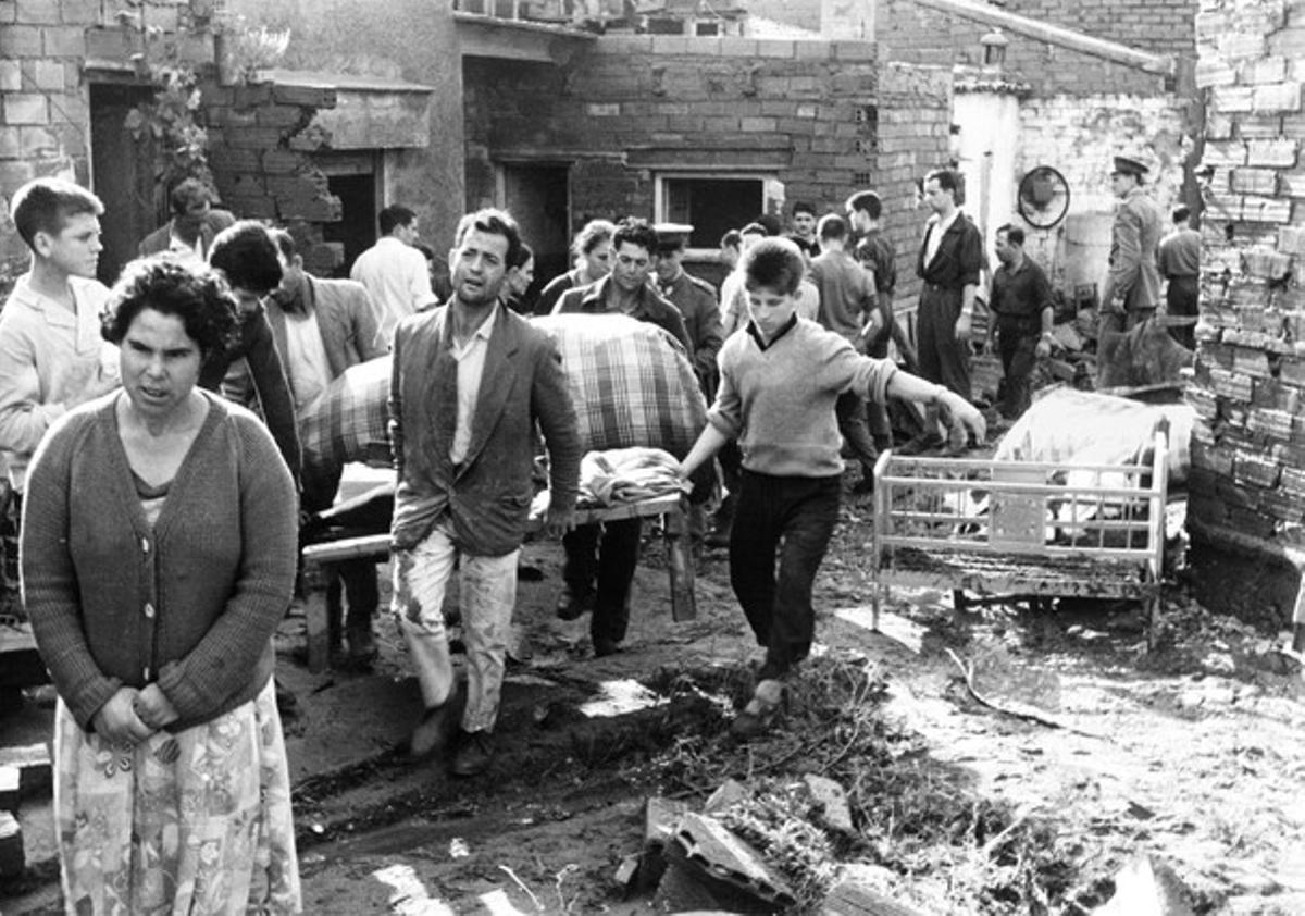 Voluntaris i veïns retiren pertinences de les vivendes que van quedar dretes després de la riuada a les Arenes, a Terrassa.