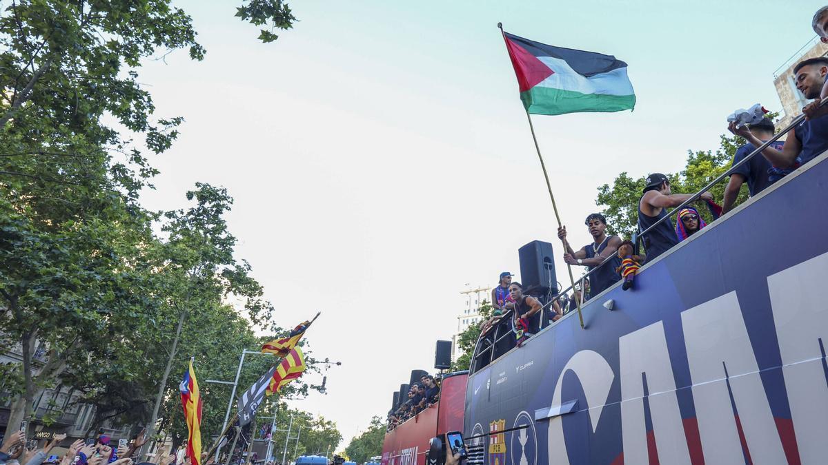 Lamine Yamal, con la bandera de Palestina durante la rúa de los campeones este lunes.