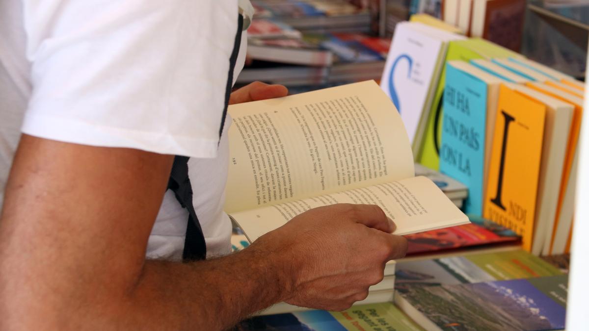 Un lector remenant llibres a la Setmana del Llibre en Català.