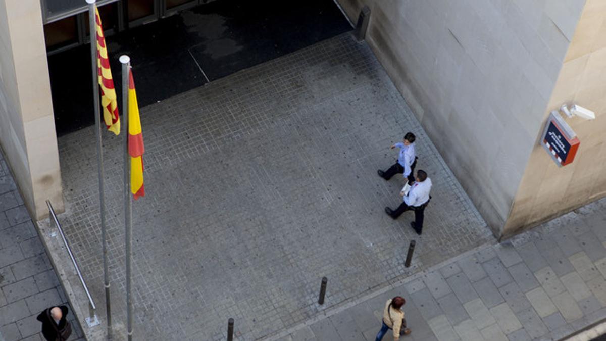 Dos agentes entran en la comisaría de los Mossos d'Esquadra de Ciutat Vella.