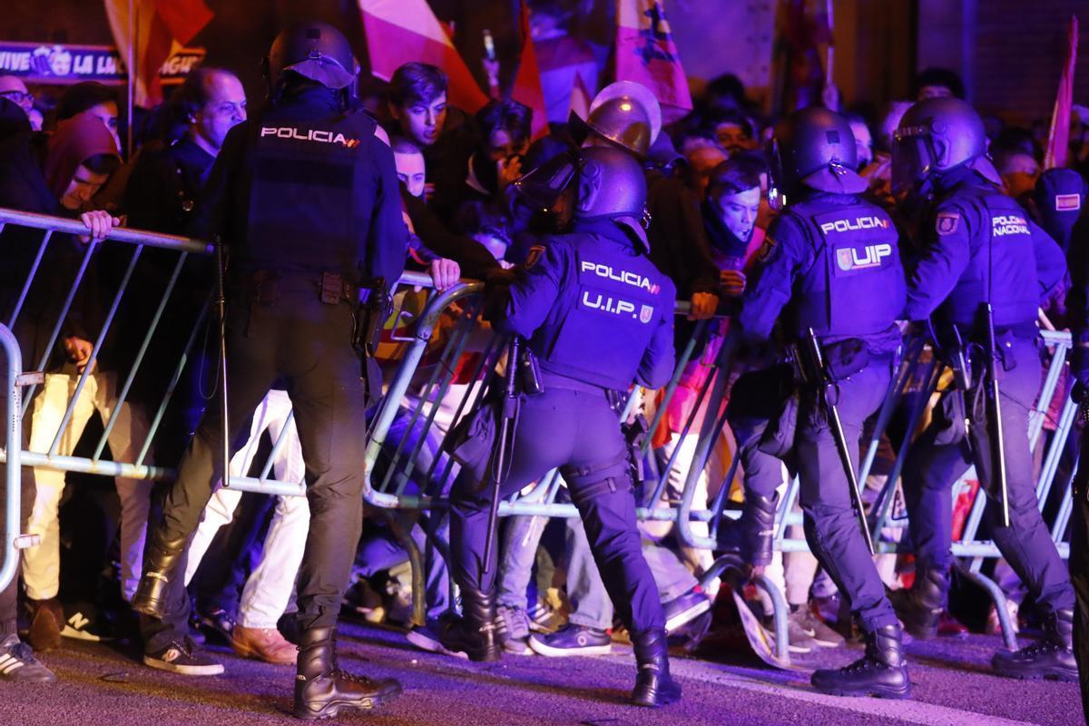 Agents de la Policia Nacional intervenen durant una concentració enfront de la seu del PSOE al carrer Ferraz.