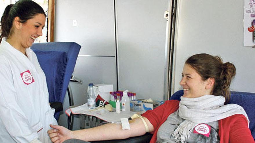 Una joven dona sangre durante una campaña en el campus universitario.