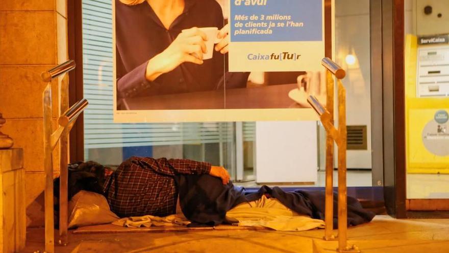 Una persona duerme a las puertas de una oficina bancaria en las calles de Palma.