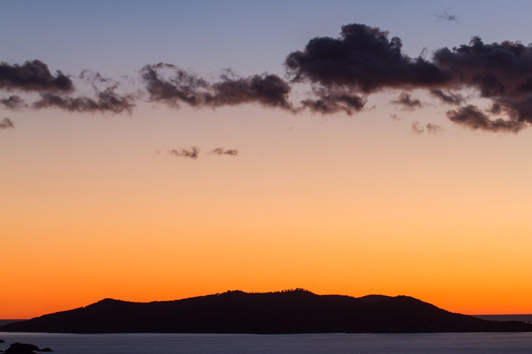 Puesta de sol desde Talamanca (Vila) con las montañas de la zona de ses Salines de fondo.