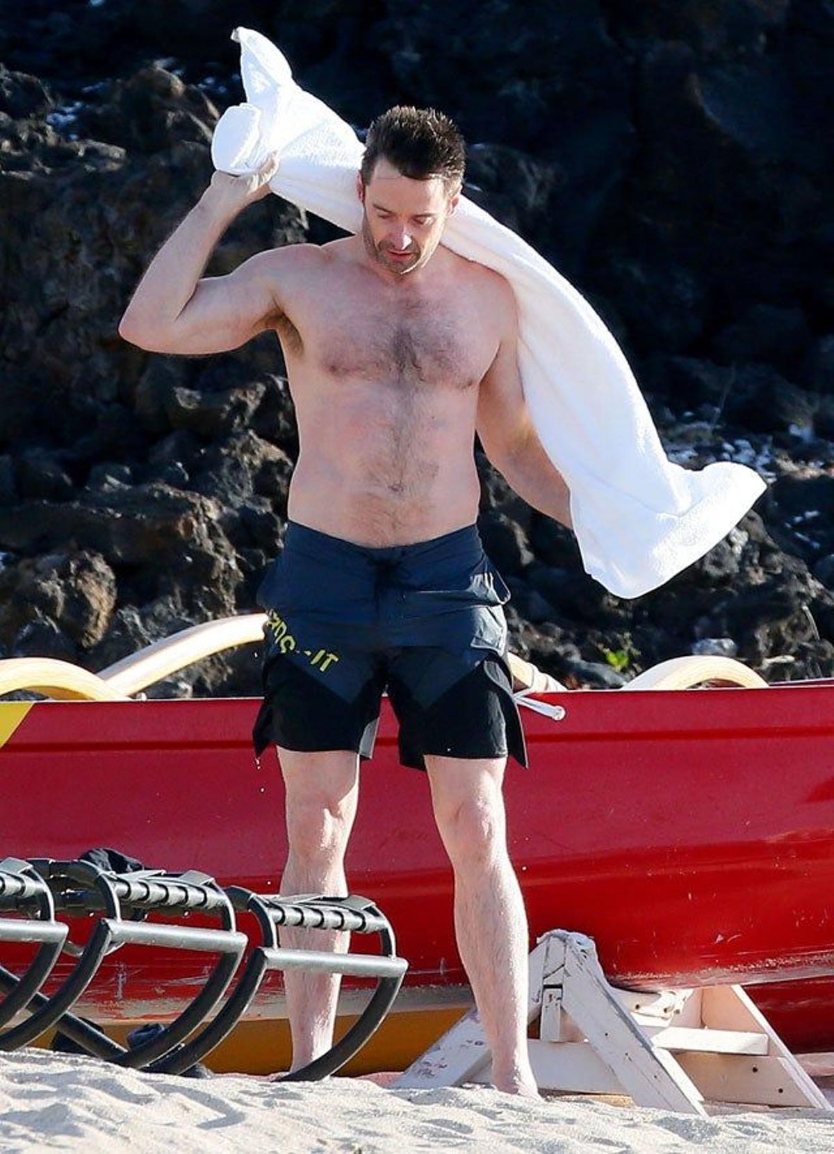 Hugh Jackman se seca la espalda con la toalla en la playa de Hawái