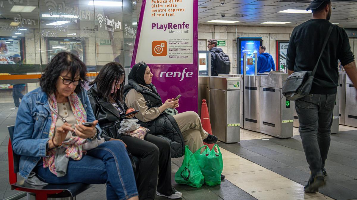 Usuarios de Rodalies informándose con sus teléfonos una vez que se recuperó la conexión a internet, el pasado 28 de abril.
