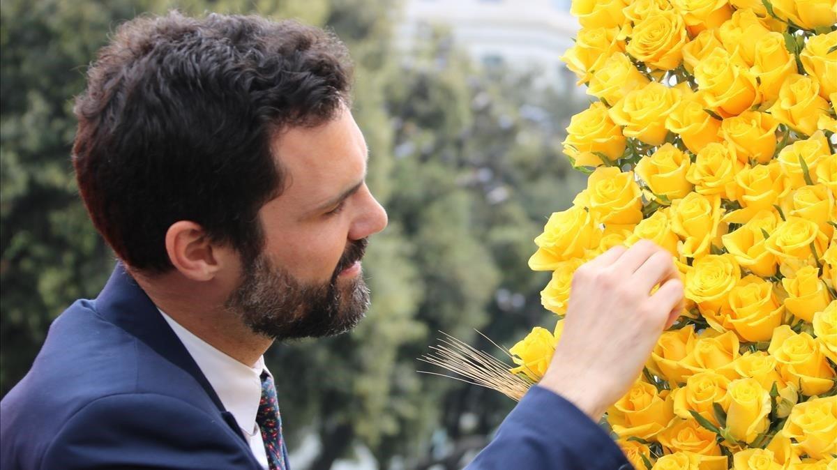 El presidente del Parlament, Roger Torrent, adornando con una rosa amarilla el mural de Ômnium.