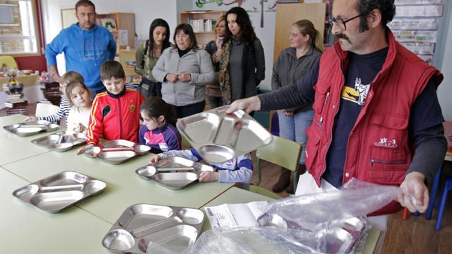 Padres y niños se repartieron ayer las bandejas de acero adquiridas para sustituir a las de plástico. // J. Lores