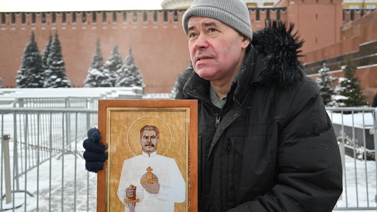 Un visitante de la necrópolis del Kremlin que lleva un icono con la imagen del dirigente soviético Iósif Stalin en Moscú.