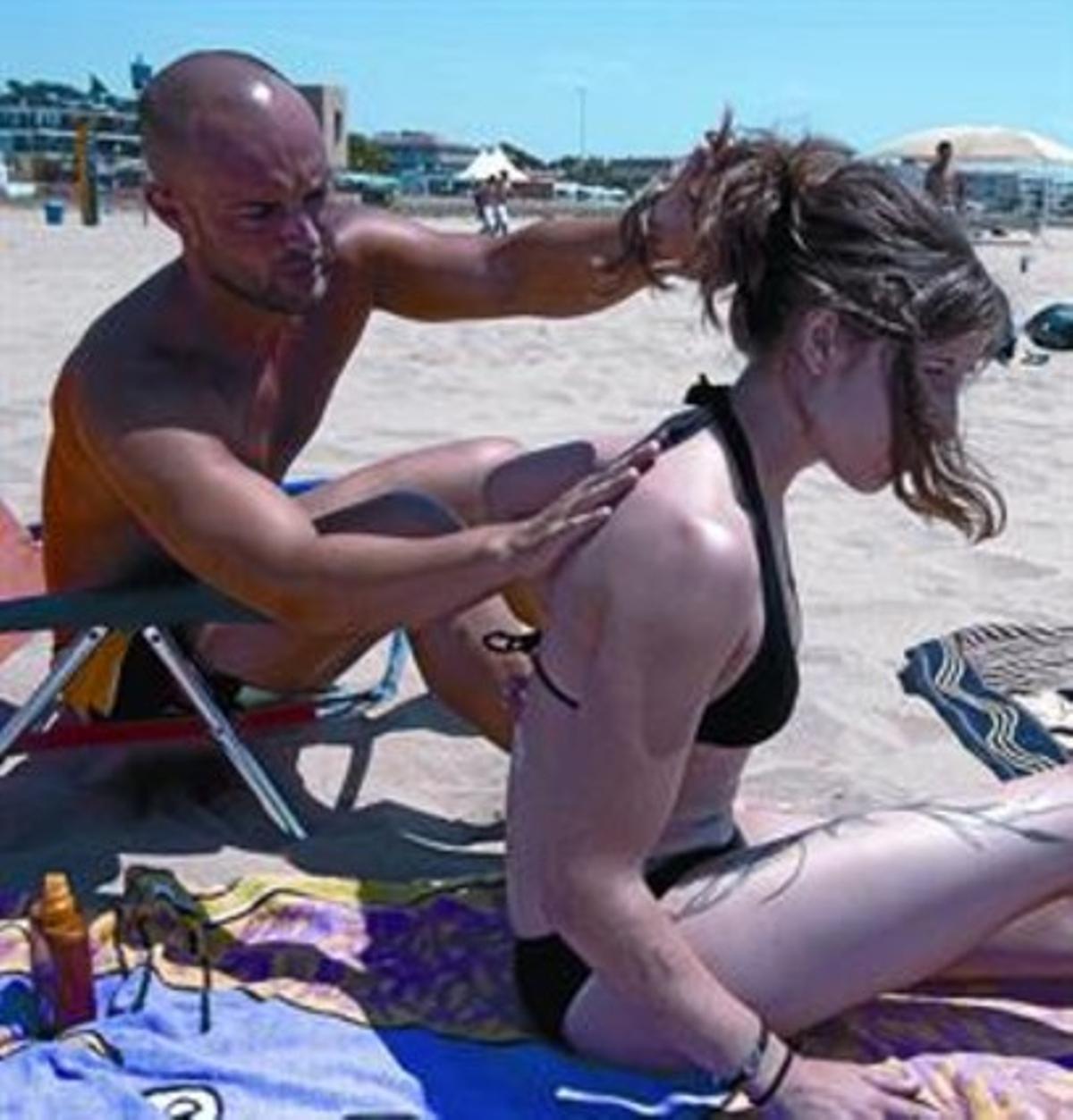 Un banyista escampa crema sobre l’esquena de la seva amiga, a Barcelona.