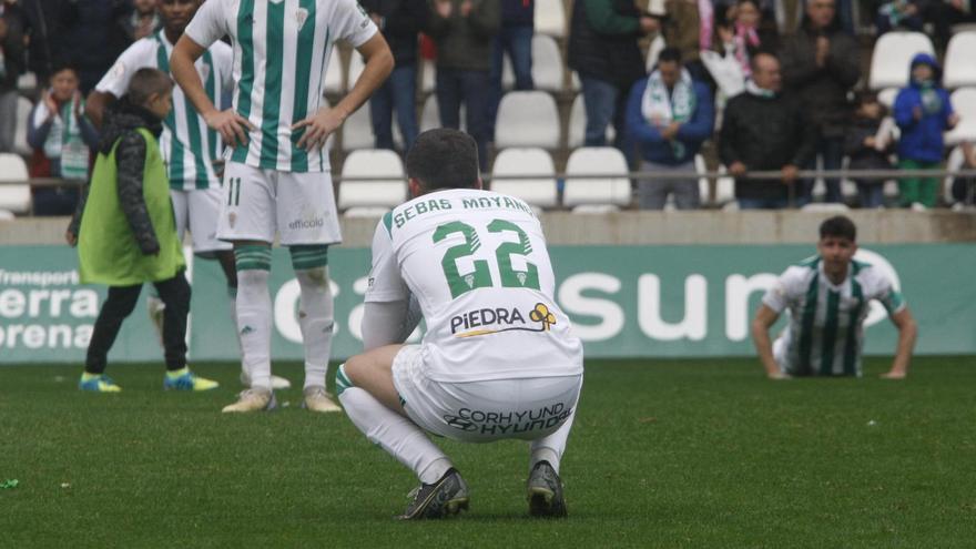 Sebas Moyano, agachado y de espaldas, el último día que pisó El Arcángel, tras la derrota ante el Marbella.