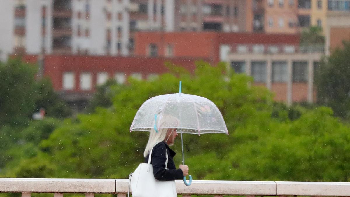 Una mujer camina bajo la lluvia.