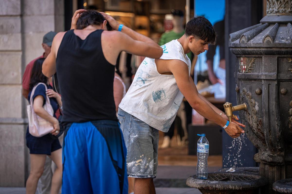 Jóvenes se refrescan en una fuente de Barcelona durante la segunda ola de calor del verano, el pasado 9 de julio