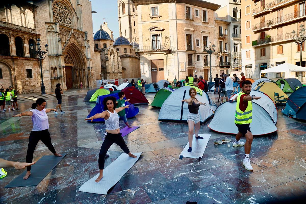 La acampada en la plaza de la Virgen de València con varias personas haciendo taichi esta mañana