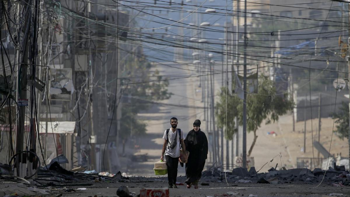 Un hombre y su madre caminan, este miércoles, por una de las devastadas calles de Gaza.