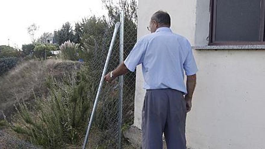 La valla rota y la ventana por donde entraron a una de las viviendas.