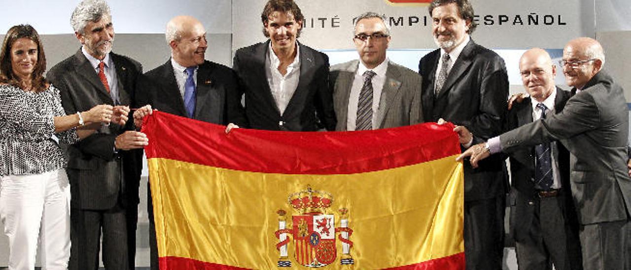 En la imagen superior e inferior el tenista Rafael Nadal, junto al ex ministro José Ignacio Wert y al presidente del Comité Olímpico Español, Alejandro Blanco, y junto a anteriores abanderados olímpicos: Isabel Fernández, Alejandro Abascal, Herminio Menéndez, Rodríguez Cal y Jaime Berenguer. Debajo, Pau Gasol en el desfile de Londres 2012, el waterpolista Manuel Estiarte en Sidney 2000 y el piraguista David Cal en Pekín 2008.