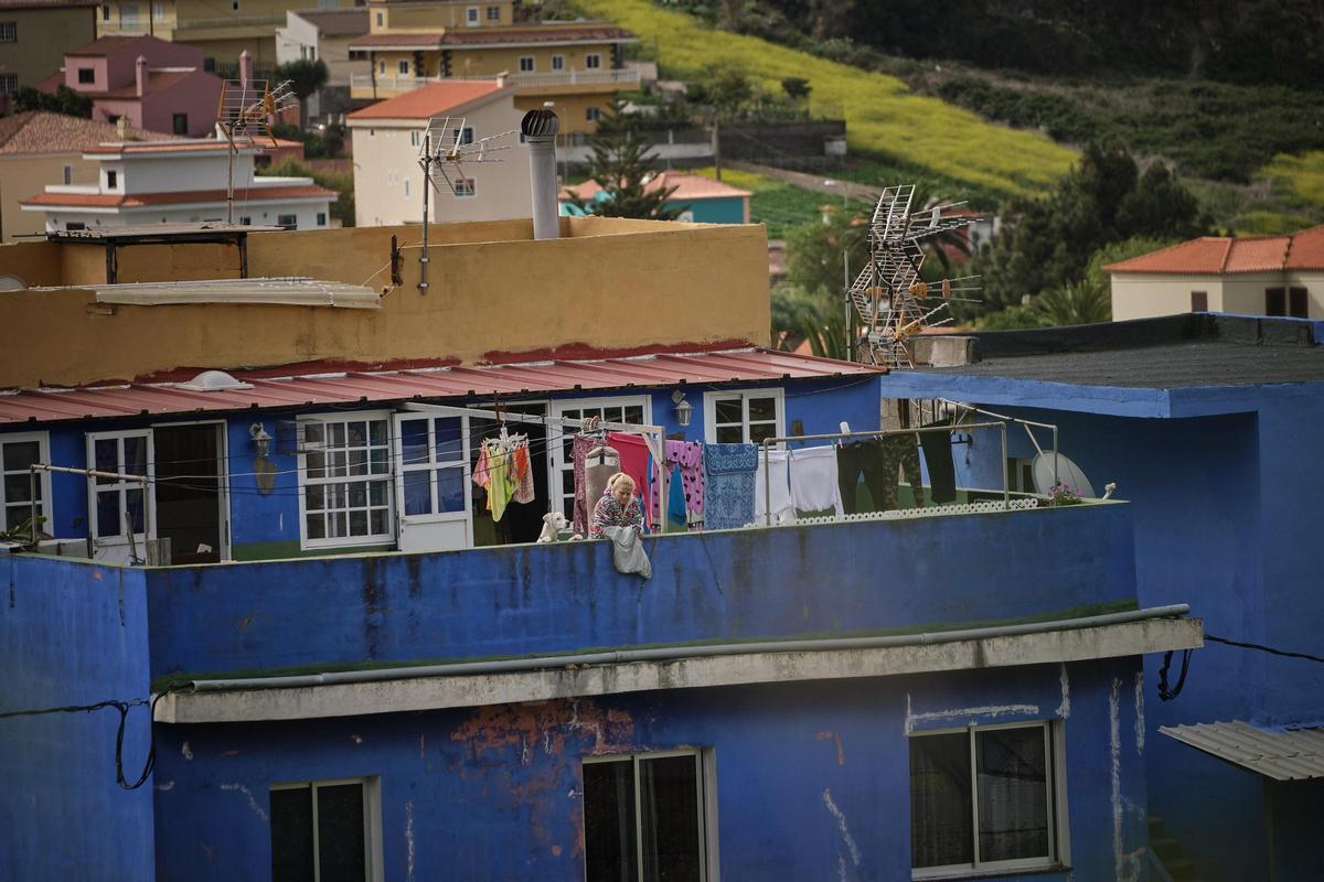 Una mujer tiende la ropa en la azotea de un edificio de viviendas de una localidad rural del Archipiélago.