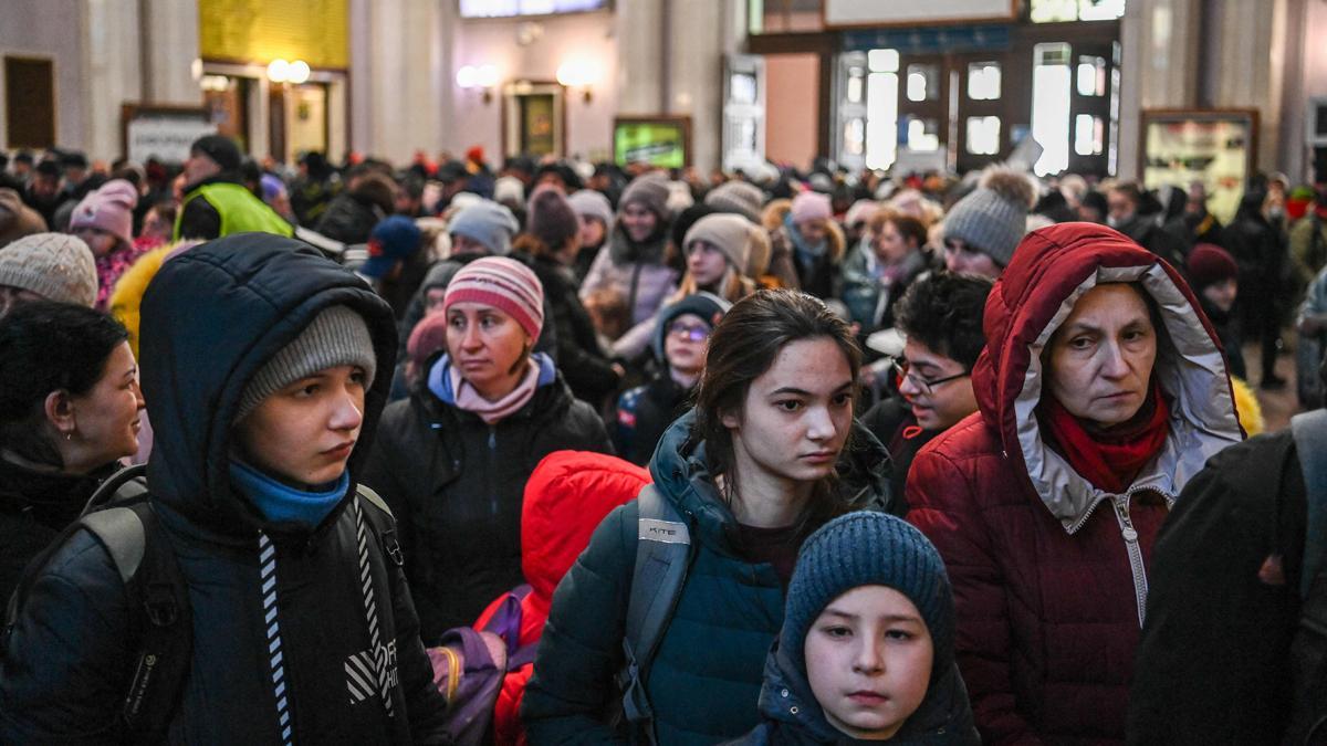 Los refugiados esperan en una larga cola para abordar un tren a Polonia en la estación central de trenes de Lviv