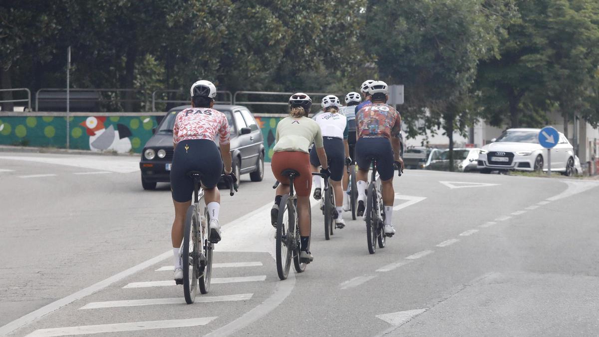 Un grup de ciclistes circulant per un carrer de Girona.