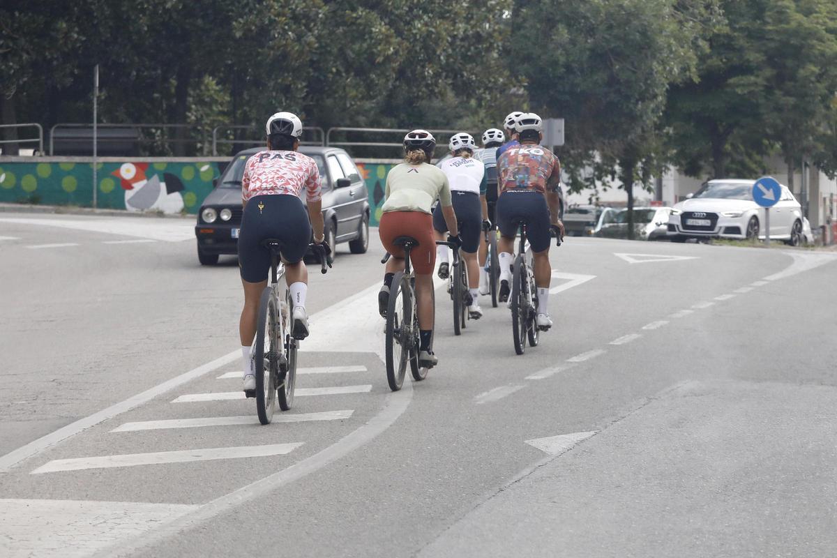 Un grup de ciclistes circulant per un carrer de Girona.