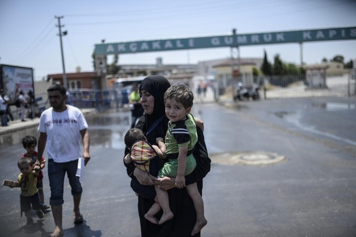 Una refugiada siria con sus dos hijos tras lograr entra en Turquía.