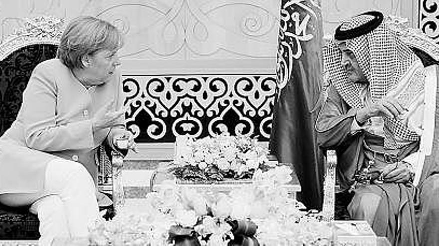 Angela Merkel conversa con el ministro de Exteriores saudí, el príncipe Saud al Faisal, ayer, en Jeddah (Arabia Saudí).