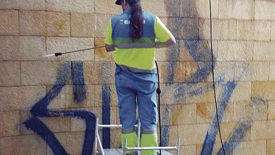 Un operario de Emaya limpiando una pintada de un muro pÃºblico.