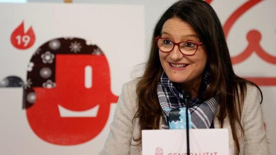La vicepresidenta, Mónica Oltra, ayer en la rueda de prensa con el pañuelo y un logo fallero.