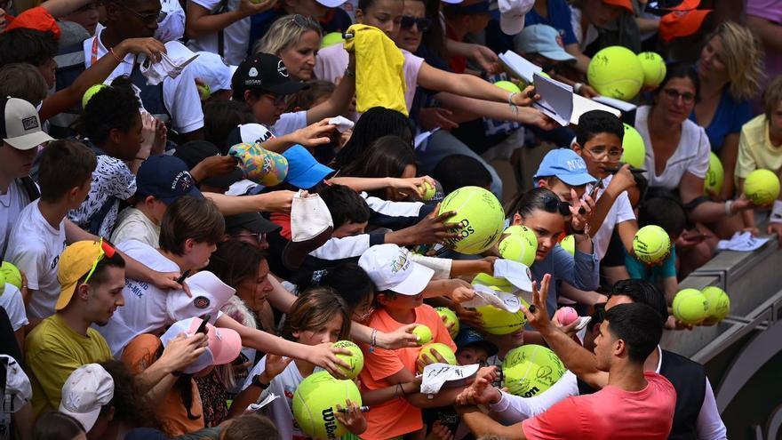 Carlos Alcaraz firma autógrafos a los aficionados en Roland Garros.