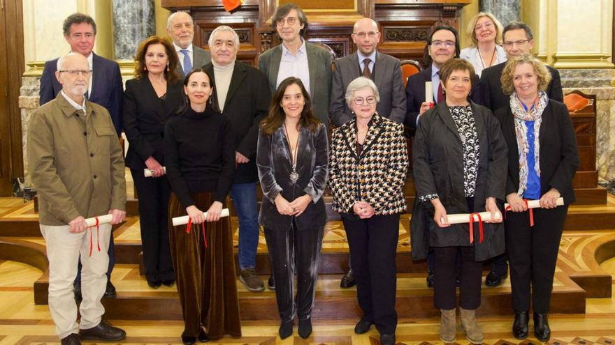 Los doce nuevos miembros colaboradores, junto a Inés Rey y Ana Romero, ayer en María Pita.  | // LOC