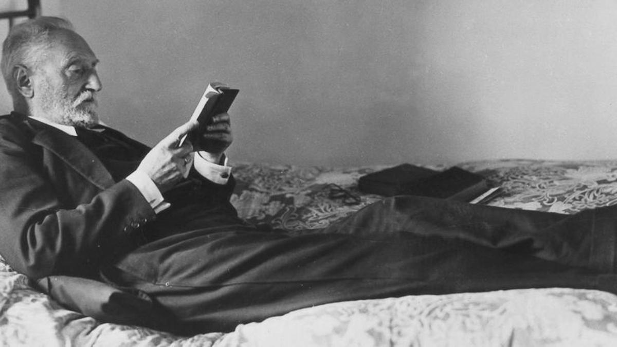 Unamuno lee recostado en la cama de su habitación en Fuerteventura.